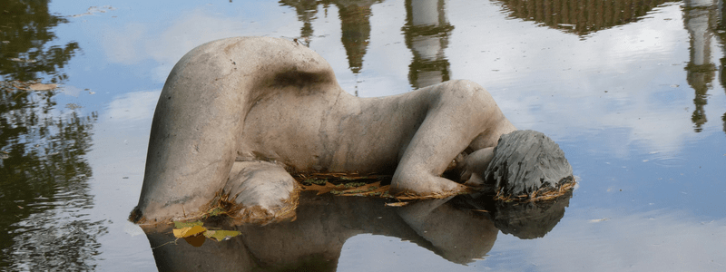 statue in a dirty pond